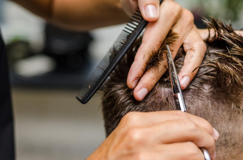 Homme se faisant couper les cheveux au ciseau